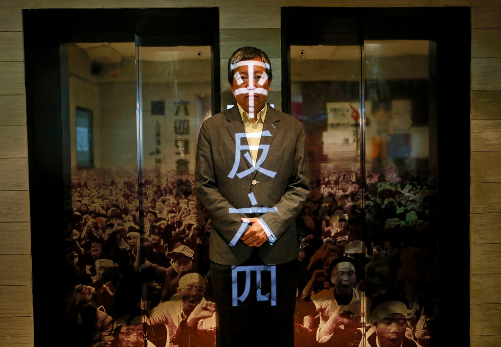 FILE - Lee Cheuk-yan poses at the June 4 Museum his pro-democracy group operates in Hong Kong on May 28, 2014. Chinese character projected on him reads "Rehabilitate the June 4th Movement". (AP Photo/Vincent Yu, File)