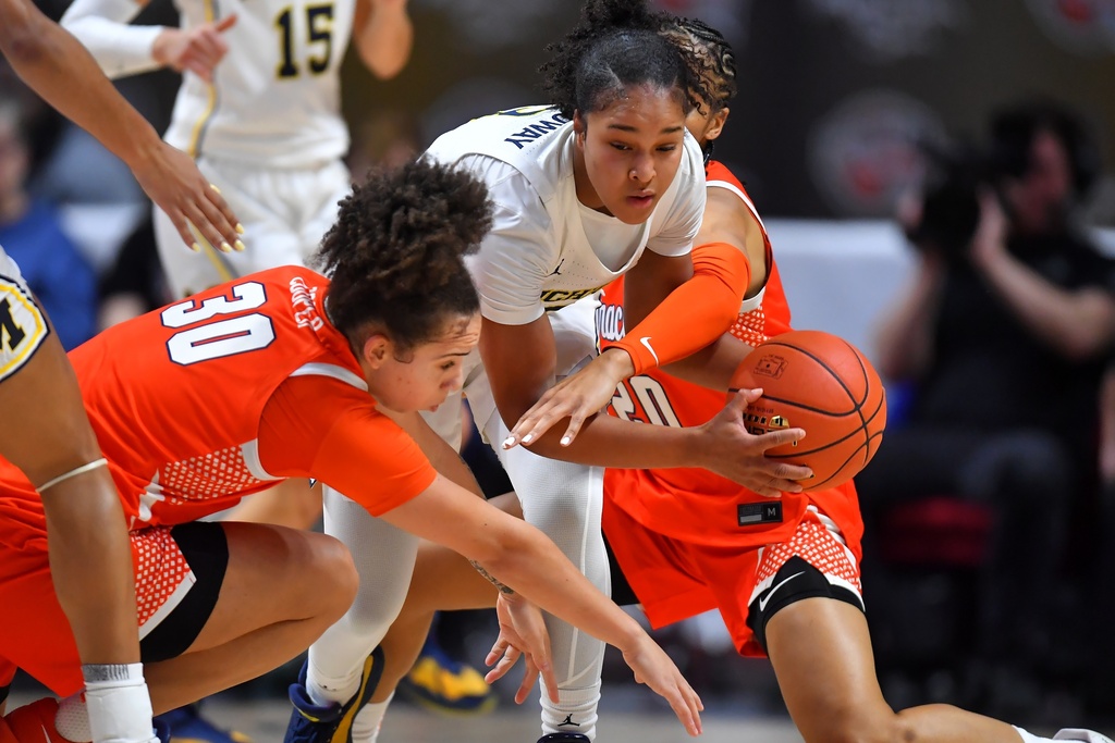 Michigan guard Mila Holloway, center, grapples with Syracuse forward Jasmyn Cooper, left, and guard Dominique Darius, back right, in the first half of an NCAA college basketball game, Sunday, Nov. 23, 2025, in Uncasville, Conn. (AP Photo/Steven Senne)