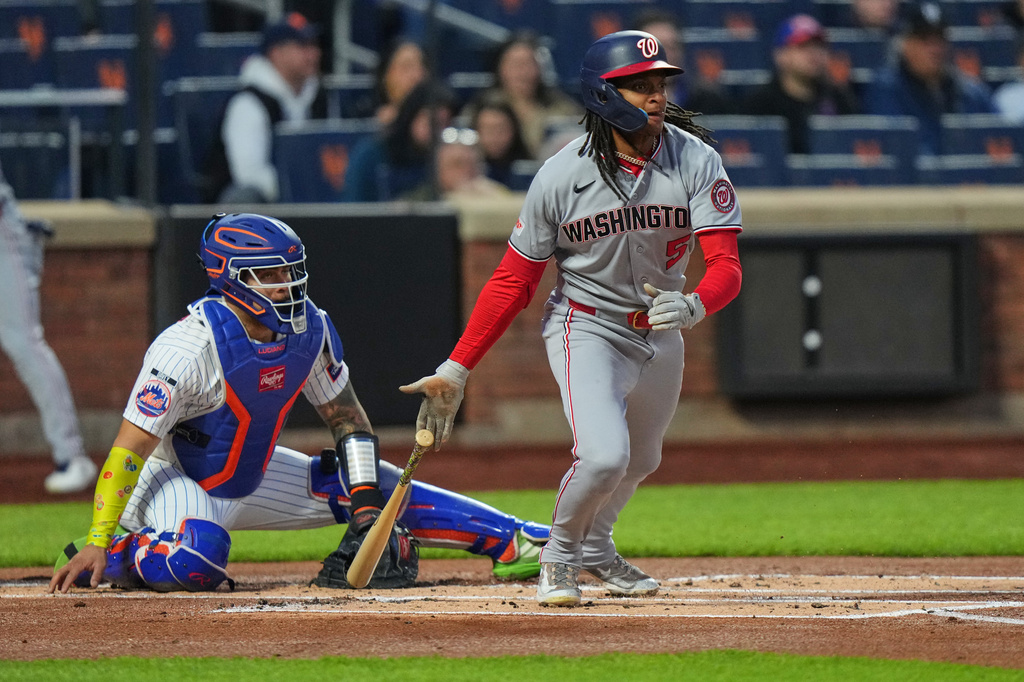 New York Mets catcher Francisco Alvarez, left, watches as Washington Nationals' CJ Abrams, right, follows through on a RBI single during the first inning of a baseball game Wednesday, April 29, 2026, in New York. (AP Photo/Frank Franklin II)