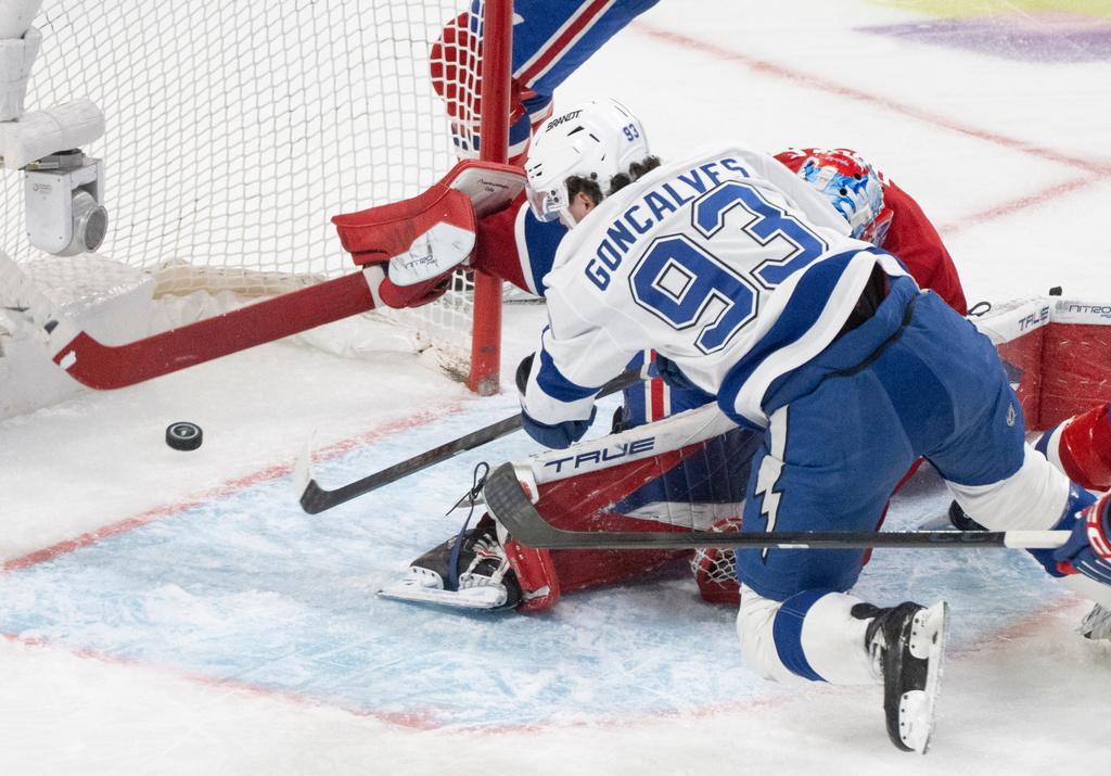 Tampa Bay Lightning's Gage Goncalves (93) scores against Montreal Canadiens goaltender Jakub Dobes, bottom, during overtime of Game 6 in the first round of an NHL hockey Stanley Cup playoff series in Montreal, Friday, May 1, 2026. (Christinne Muschi/The Canadian Press via AP)