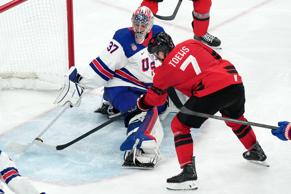 United States goalkeeper Connor Hellebuyck (37) uses his stick to block a shot by Canada's Devon Toews (7) during the third period of the men's ice hockey gold medal game at the 2026 Winter Olympics in Milan, Italy, Sunday, Feb. 22, 2026. (AP Photo/Carolyn Kaster)