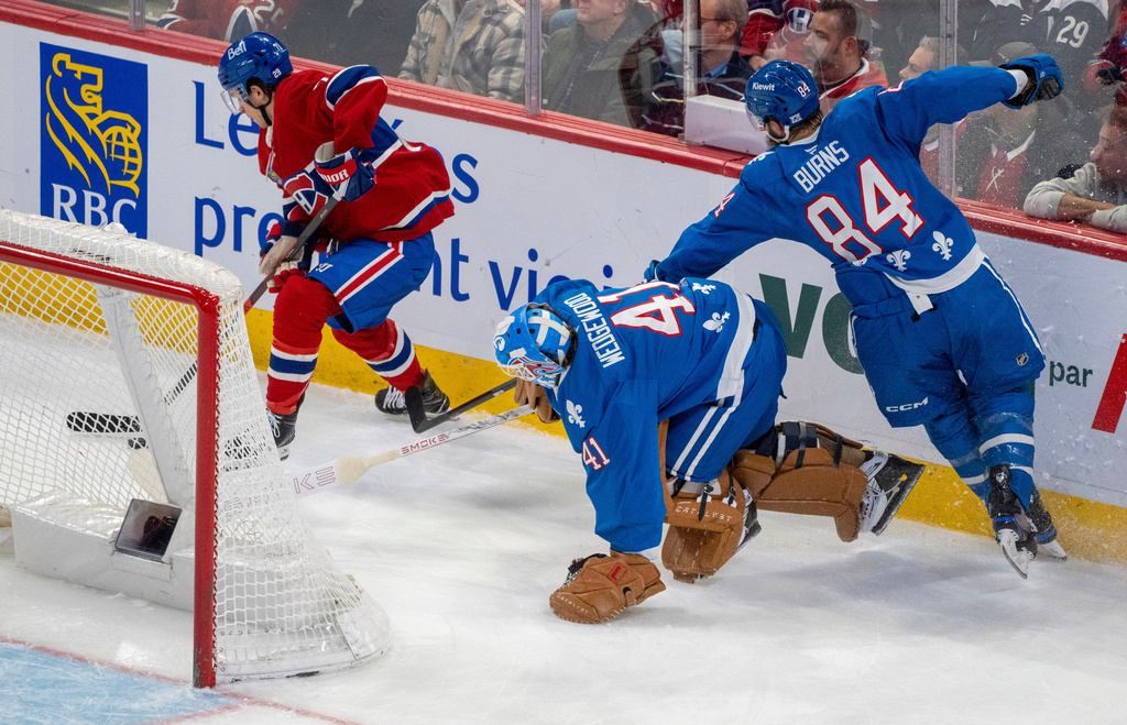 Montreal Canadiens' Jake Evans (71) beats Colorado Avalanche goaltender Scott Wedgewood (41) behind the net to score during the second period of an NHL hockey game in Montreal, Thursday, Jan. 29, 2026. (Christinne Muschi/The Canadian Press via AP)