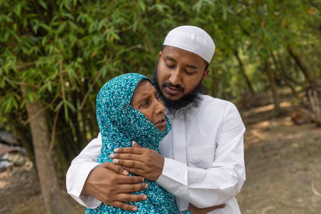 Maruf Hasan, brother of Mohammad Abdullah Al Mamun comforts his mother, Shahida Khatun, as she weeps at their home in Rasulpur village in Mymensingh district, Bangladesh, Friday, April 17, 2026. (AP Photo/Rajib Dhar)