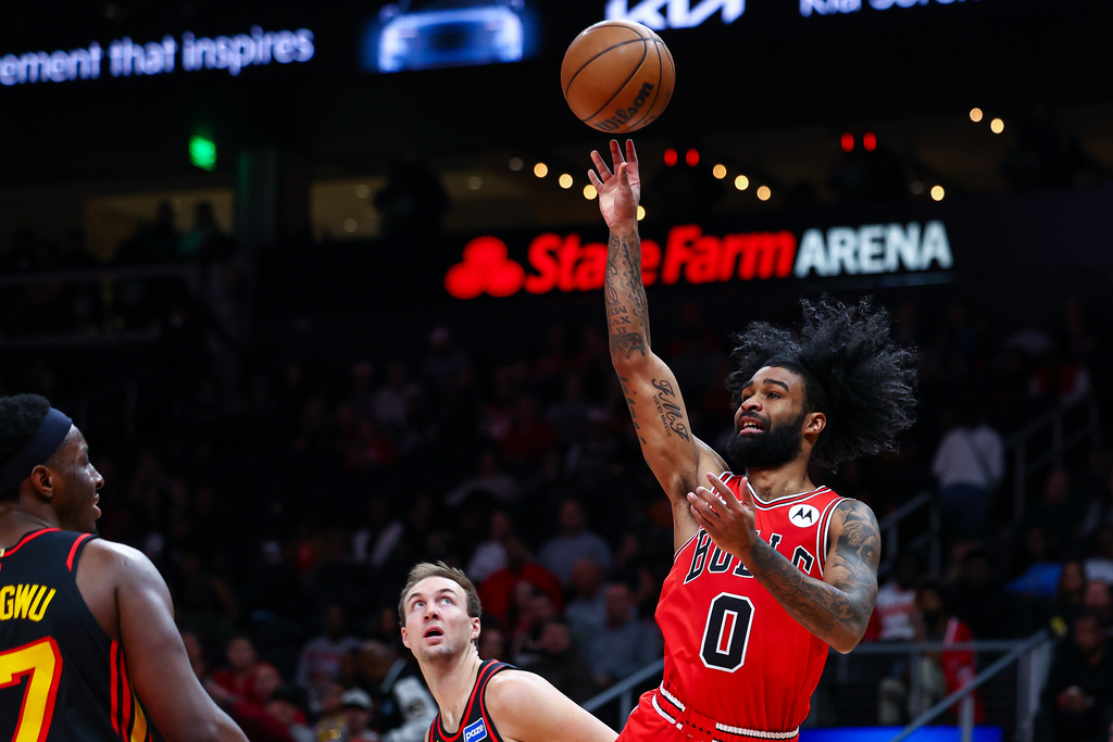 Chicago Bulls guard Coby White (0) shoots over Atlanta Hawks forward Onyeka Okongwu, left, during the first half of an NBA basketball game, Sunday, Dec. 21, 2025, in Atlanta. (AP Photo/Colin Hubbard)
