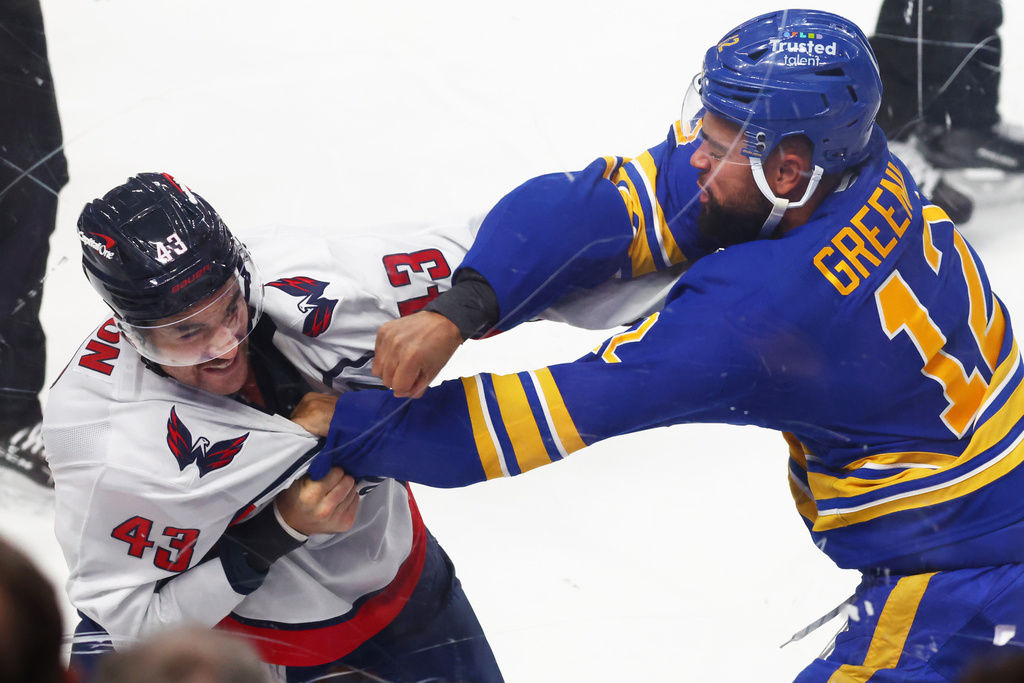 Buffalo Sabres Jordan Greenway (12) and Washington Capitals right wing Tom Wilson (43) fight during the first period of an NHL hockey game Saturday, Nov. 1, 2025, in Buffalo, N.Y. (AP Photo/Jeffrey T. Barnes)