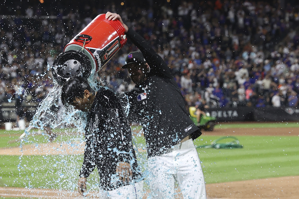New York Mets' Jonah Tong, left, is doused with water after defeating the Miami Marlins during a baseball game Friday, Aug. 29, 2025, in New York. (AP Photo/Pamela Smith)