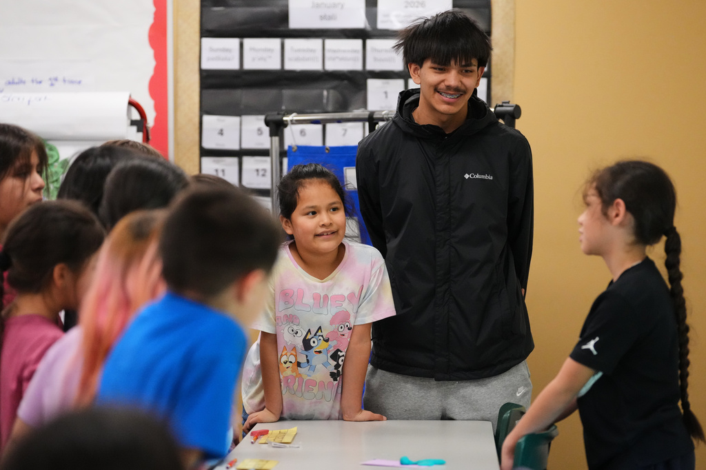 Chief Leschi Schools senior Gerald Dillon, 18, who serves as a teaching assistant through the school's career and technical education program, listens to a second grade student describe the parts of their Play-Doh insect in class Wednesday, March 18, 2026, at Chief Leschi Schools in Puyallup, Wash. (AP Photo/Lindsey Wasson)
