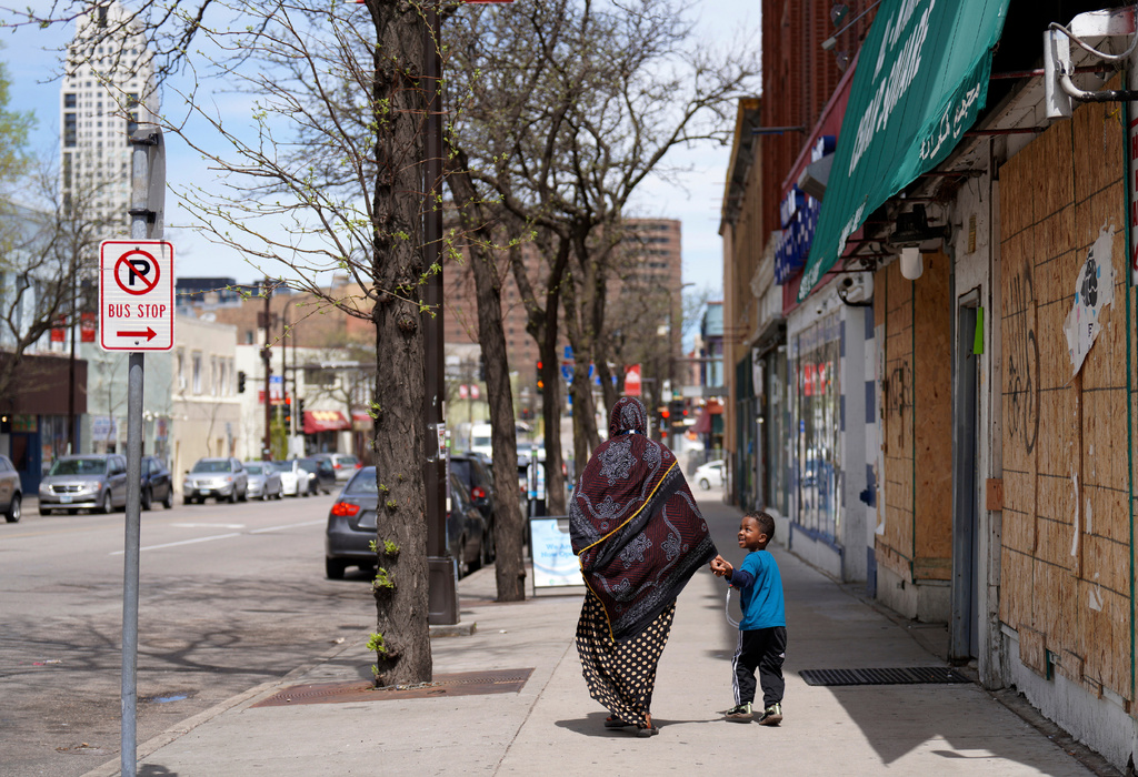 FILE - A woman and a child hold hands as they walk down a street in the predominantly Somali neighborhood of Cedar-Riverside in Minneapolis on Thursday, May 12, 2022. (AP Photo/Jessie Wardarski, File)