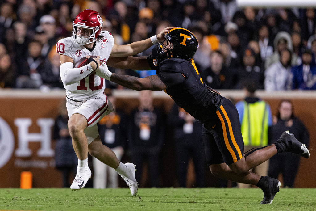 Oklahoma quarterback John Mateer (10) stiff arms Tennessee defensive lineman Daevin Hobbs (5) as he runs for yardage during the first half of an NCAA college football game Saturday, Nov. 1, 2025, in Knoxville, Tenn. (AP Photo/Wade Payne)