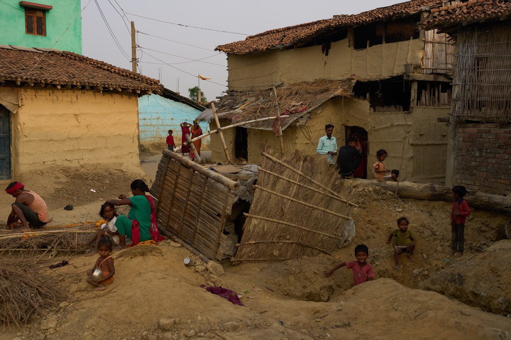 Residents sit outside their homes in Gaur, Nepal, on May 19, 2026. (AP Photo/Bram Janssen)