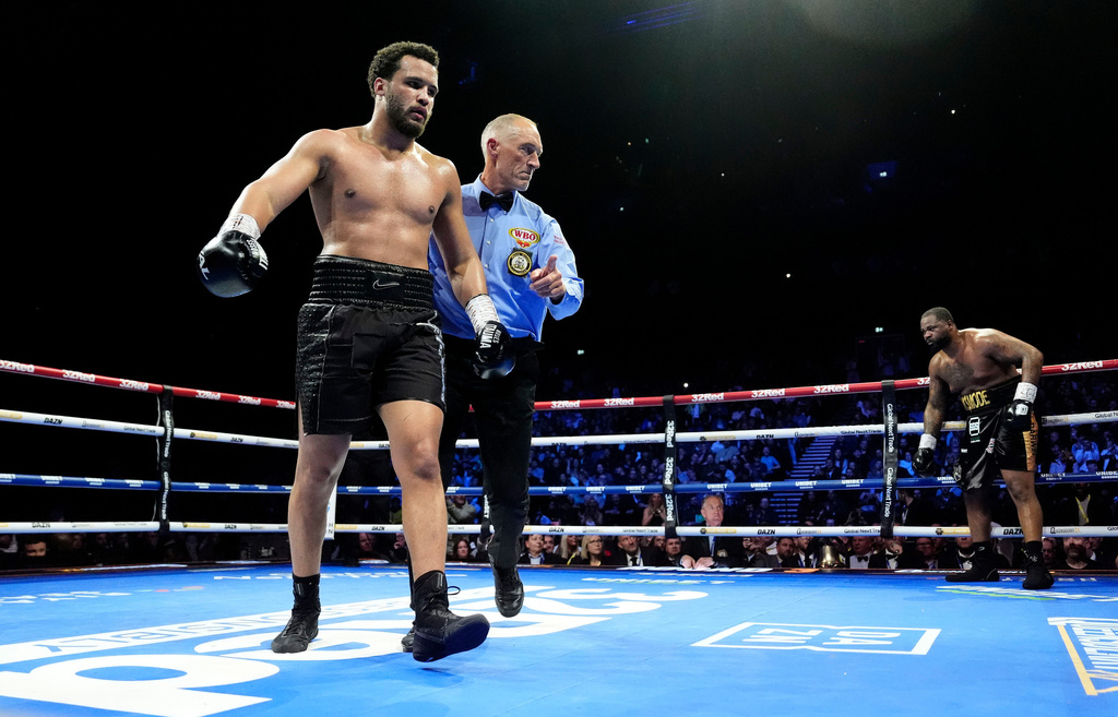 Boxer Moses Itauma, left, is directed to a corner after knocking down Jermaine Franklin during a WBA International and WBO Inter-Continental Heavyweight bout against Jermaine Franklin, Saturday, March 28, 2026, in Manchester, England. (Nick Potts/PA via AP)