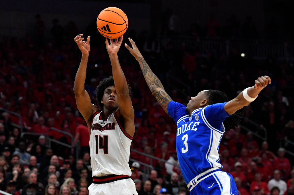 Louisville guard Adrian Wooley (14)shoots over Duke guard Isaiah Evans (3) during the second half of an NCAA college basketball game in Louisville, Ky., Tuesday, Jan. 6, 2026. (AP Photo/Timothy D. Easley)