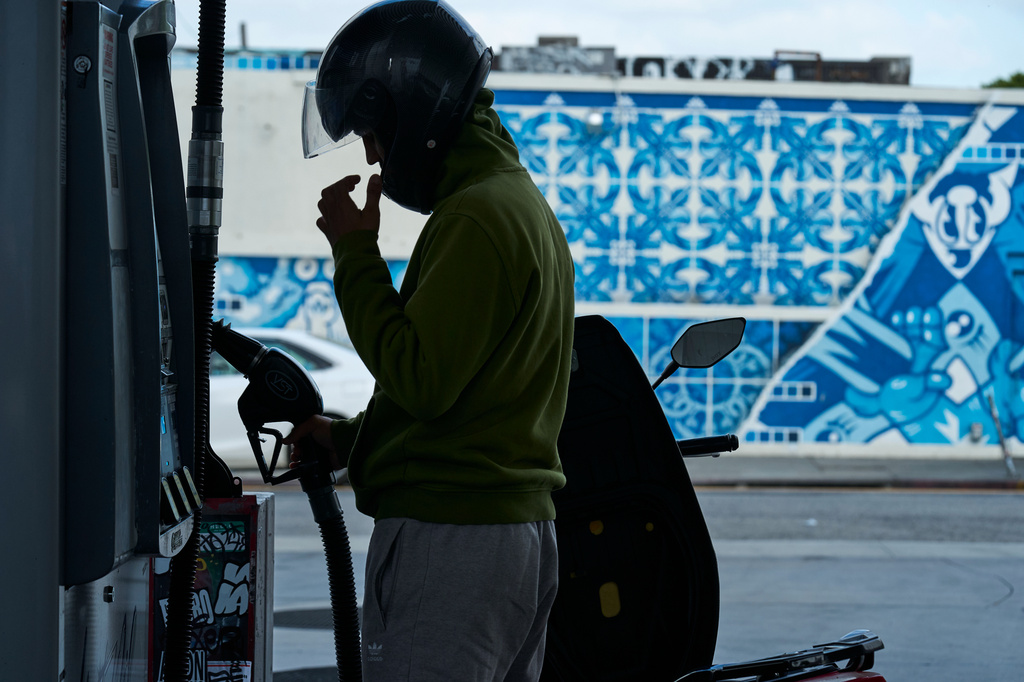 Neer Malik fills up just one gallon of gasoline to ride approximately 100 miles on his motorcycle at a gas station in Los Angeles on Friday, April 17, 2026. (AP Photo/Damian Dovarganes)