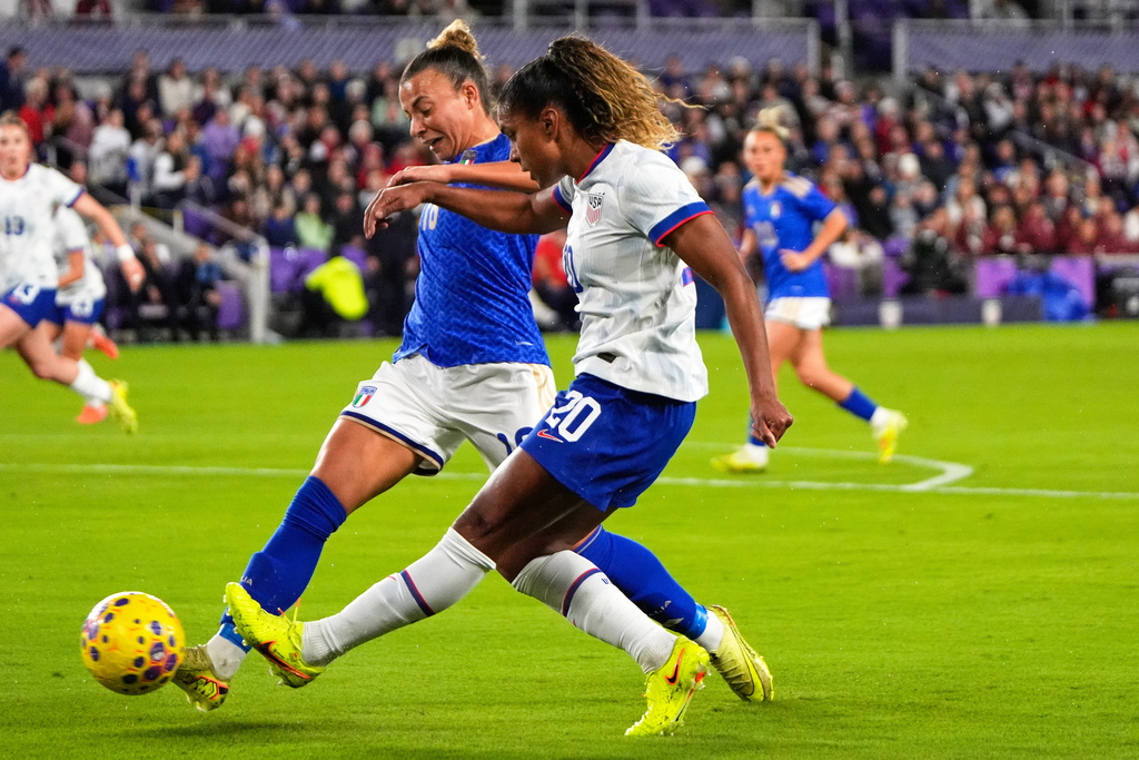 United States midfielder Catarina Macario (20) shoots on goal against Italy midfielder Arianna Caruso, left, during the first half of an international friendly soccer match Friday, Nov. 28, 2025, in Orlando, Fla. (AP Photo/John Raoux)
