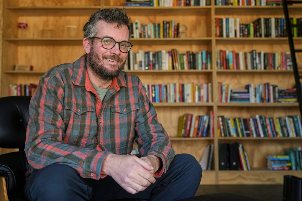 FILE - Author John Green poses in his studio in Indianapolis on Jan. 21, 2026. (AP Photo/Michael Conroy, File)