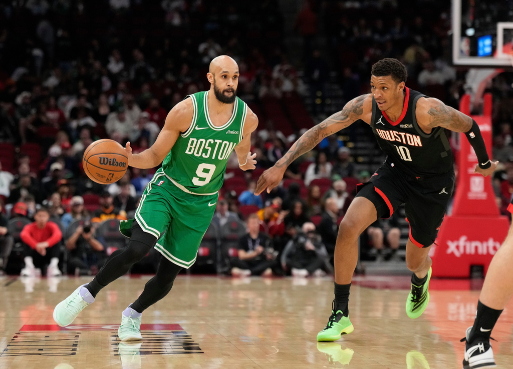 Boston Celtics guard Derrick White (9) controls the ball against Houston Rockets forward Jabari Smith Jr. (10) during the first half of an NBA basketball game, in Houston, Wednesday, Feb. 4, 2026. (AP Photo/ Karen Warren)