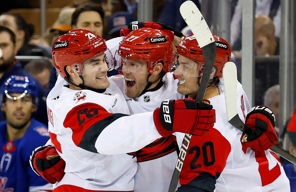 Carolina Hurricanes left wing Nikolaj Ehlers, center, celebrates with Sean Walker (26) and Sebastian Aho (20) after scoring a goal against the New York Rangers during the first period of an NHL hockey game, Tuesday Nov. 4, 2025, in New York. (AP Photo/Noah K. Murray)