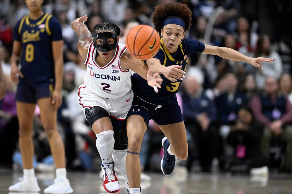 UConn guard KK Arnold (2) and Notre Dame guard Hannah Hidalgo (3) chase the ball in the second half of an NCAA college basketball game, Monday, Jan. 19, 2026, in Storrs, Conn. (AP Photo/Jessica Hill)