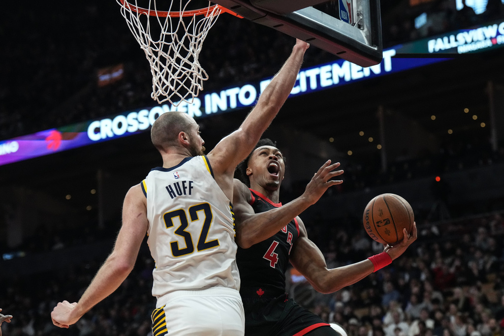 Toronto Raptors forward Scottie Barnes (4) goes to the net on Indiana Pacers centre Jay Huff (32) during first half NBA Cup basketball action in Toronto on Wednesday, Nov. 26, 2025. (Chris Young/The Canadian Press via AP)