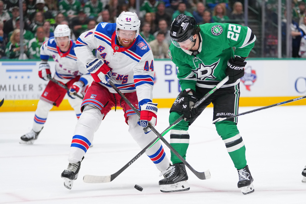 New York Rangers defenseman Vladislav Gavrikov (44) and Dallas Stars center Mavrik Bourque (22) compete for possession of the puck during the first period of an NHL hockey game Saturday, April 11, 2026, in Dallas. (AP Photo/Julio Cortez)