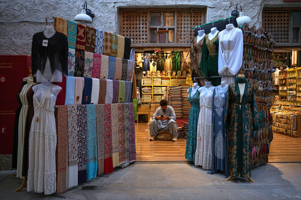 FILE - A vendor sits inside a shop at the empty Al Seef market, one of the main tourist areas of Dubai, United Arab Emirates, March 13, 2026, as tourism slows during the Iran war. (AP Photo/Fatima Shbair, File)
