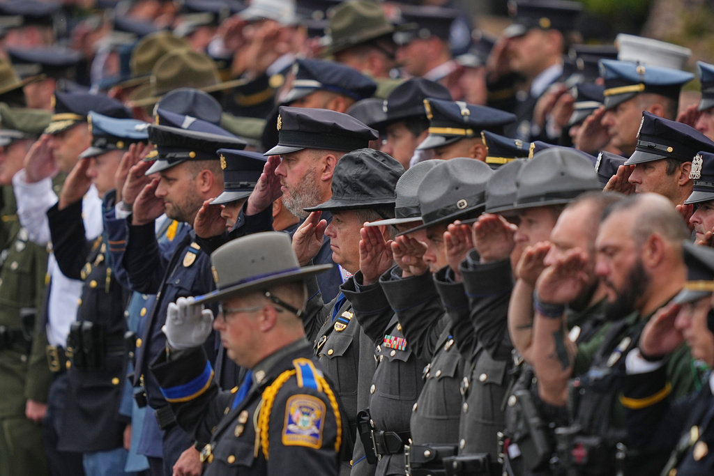 Officers salute during a procession for slain Northern York County Regional Police detectives Cody Michael Becker, Mark Edward Baker and Isaiah Emenheiser, Thursday, Sept. 25, 2025, in Red Lion, Pa. (AP Photo/Matt Rourke)