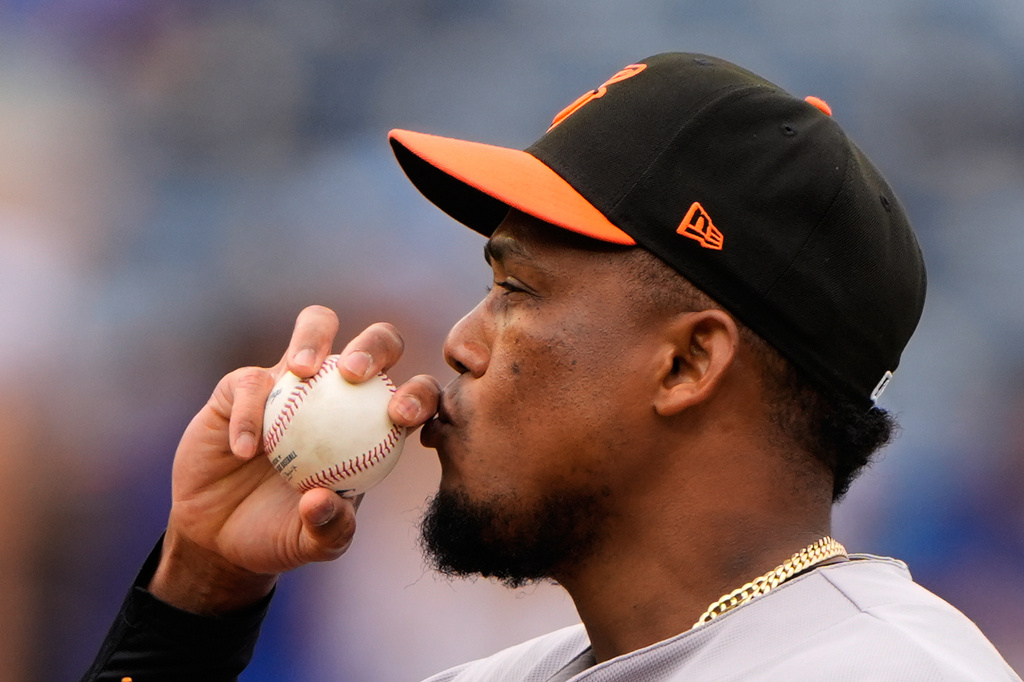 Baltimore Orioles relief pitcher Yennier Cano kisses a baseball before throwing during the sixth inning of a baseball game against the Kansas City Royals, Wednesday, April 22, 2026, in Kansas City, Mo. (AP Photo/Charlie Riedel)
