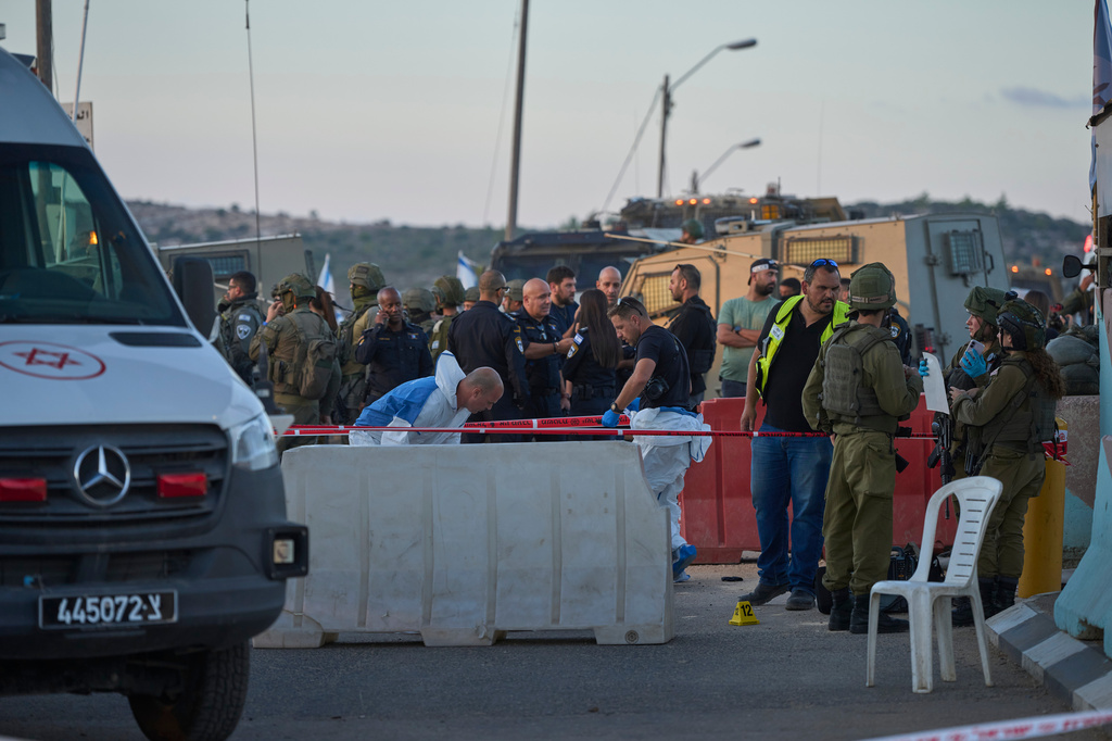 Israeli security forces inspect the scene where, according to police, a Palestinian man was shot and killed after ramming his car into a security checkpoint and seriously wounding an officer, near the West Bank Jewish settlement of Beit Horon, Wednesday, Sept. 23, 2026.(AP Photo/Ohad Zwigenberg)