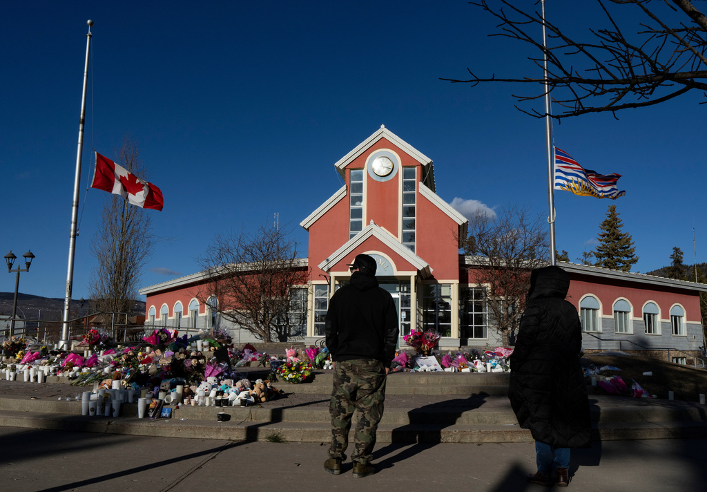 FILE - People pay their respects at a memorial on the steps of the Town Hall following a vigil the previous day in Tumbler Ridge, B.C., Saturday, Feb. 14, 2026. (Christinne Muschi/The Canadian Press via AP, file)