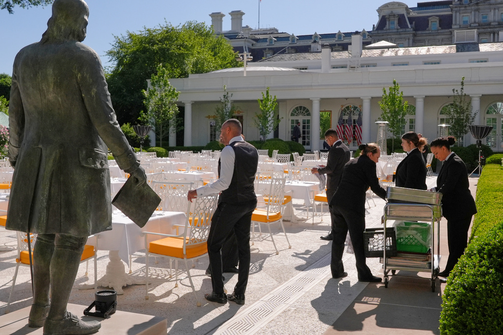 FILE - A statue of Ben Franklin is seen as servers prepare the Rose Garden for a dinner after President Donald Trump hosted the 2026 College Football Playoff national champions Indiana University on the South Lawn of the White House, May 11, 2026, in Washington. (AP Photo/Jacquelyn Martin, File)