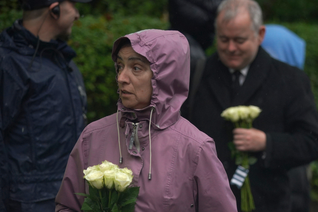 A woman carries white roses as she attends a vigil for the victims of the attack on at Heaton Park Hebrew Congregation synagogue, in Crumpsall, Manchester, England, Friday, Oct. 3, 2025. (AP Photo/Ian Hodgson)