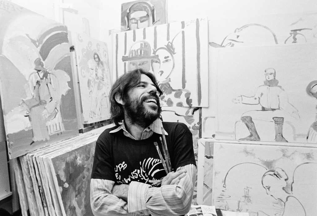 FILE - Peter Max, the bearded artist who spurred cosmic art forms in the 1960s, sits among some of his minute-by-minute creations in his New York studio on Nov. 11, 1973. (AP Photo/Dave Pickoff, File)