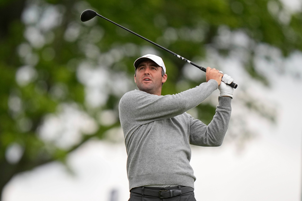 Fans watch Scottie Scheffler hits on the eighth green during the first round of the PGA Championship golf tournament at Aronimink Golf Club, Thursday, May 14, 2026, in Newtown Square, PA. (AP Photo/Frank Franklin II)
