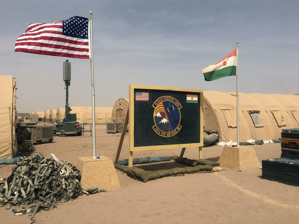 FILE- In this file photo taken Monday, April 16, 2018, a U.S. and Niger flag are raised side by side at the base camp for air forces and other personnel supporting the construction of Niger Air Base 201 in Agadez, Niger. The US handed over its last military base in Niger to the country's authorities, the US Department of Defense and Niger&rsquo;s Ministry of Defense announced in a joint statement on Monday, Aug. 5, 2024. (AP Photo/Carley Petesch, File)