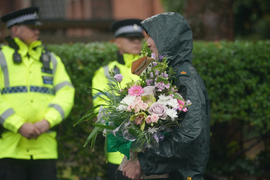 A woman brings flowers as she attends a vigil for the victims of the attack on the Heaton Park Hebrew Congregation synagogue, in Crumpsall, Manchester, England, Friday, Oct. 3, 2025, the attack happened Thursday. (AP Photo/Ian Hodgson)