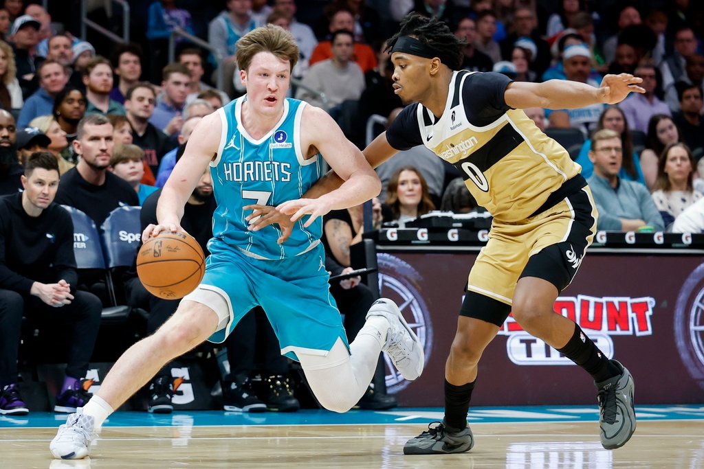 Charlotte Hornets guard Kon Knueppel, left, drives against Washington Wizards guard Bilal Coulibaly (0) during the first half of an NBA basketball game in Charlotte, N.C., Tuesday, Dec. 23, 2025. (AP Photo/Nell Redmond)