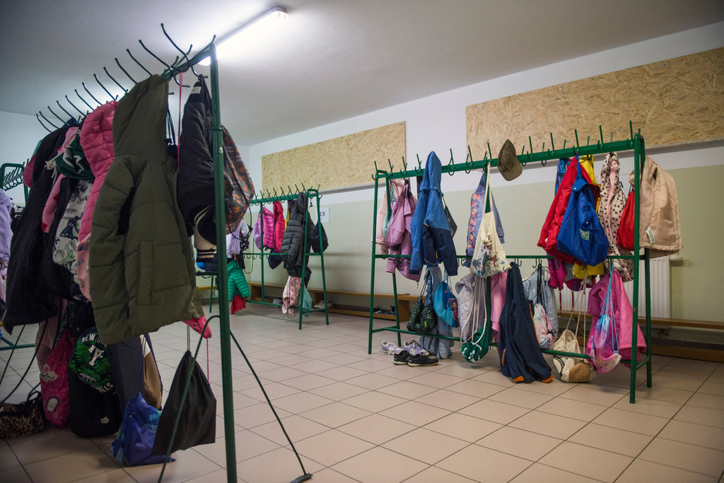 Children's jackets and bags hang on racks inside a school cloakroom that has been converted into a makeshift bomb shelter to ensure safety for students in Dorohusk, Poland, on Sept. 24, 2026. (AP Photo/Attila Husejnow)