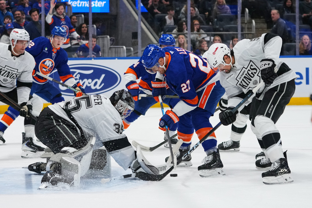 Los Angeles Kings goaltender Darcy Kuemper (35) and Cody Ceci (5) protects the net from New York Islanders' Anders Lee (27) during the second period of an NHL hockey game Friday, March 13, 2026, at UBS Arena in Elmont, N.Y. (AP Photo/Frank Franklin II)