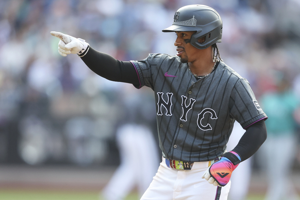 New York Mets' Francisco Lindor points to the dugout after reaching first base during the seventh inning of a baseball game against the Seattle Mariners, Saturday, Aug. 16, 2025, in New York. (AP Photo/Heather Khalifa)