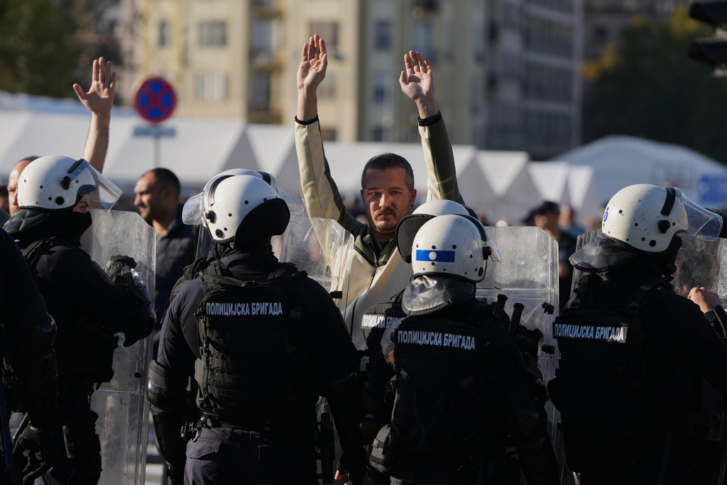 Serbian police guard a camp of President Aleksandar Vucic's loyalists as Dijana Hrka, the mother of one of 16 victims of a train station tragedy in northern Serbia a year ago, launched a hunger strike surrounded by anti-government protesters in Belgrade, Serbia, Sunday, Nov. 2, 2025. (AP Photo/Darko Vojinovic)