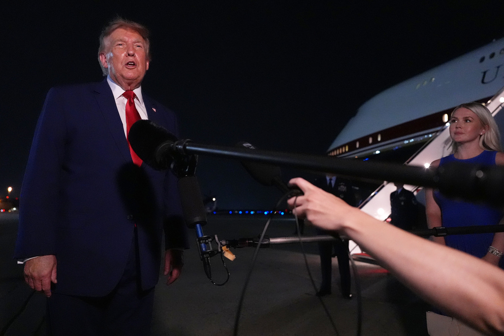 President Donald Trump talks to reporters after arriving on Air Force One Tuesday, Aug. 11, 2026, at Joint Base Andrews, Md., as White House press secretary Karoline Leavitt listens. (AP Photo/Mark Schiefelbein)