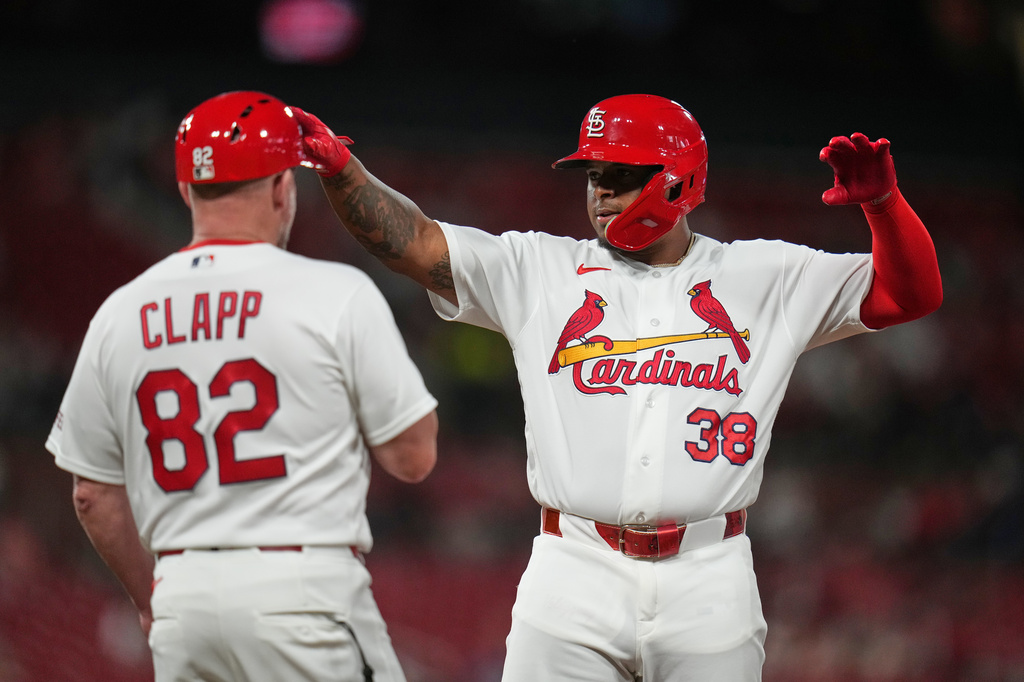 St. Louis Cardinals' Nelson Velázquez (38) celebrates after hitting an RBI single as first base coach Stubby Clapp (82) watches during the sixth inning of a baseball game against Texas Rangers Wednesday, June 3, 2026, in St. Louis. (AP Photo/Jeff Roberson)