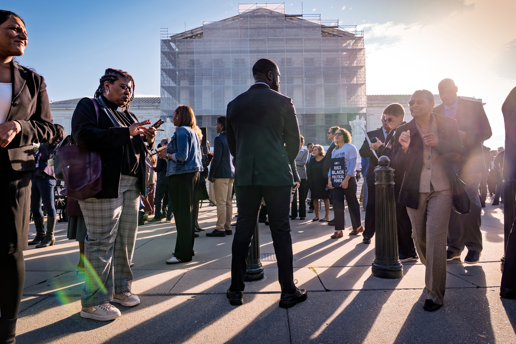 Voting rights activists gather outside the Supreme Court in Washington, early Wednesday, Oct. 15, 2025, as the justices prepare to take up a major Republican-led challenge to the Voting Rights Act, the centerpiece legislation of the Civil Rights Movement. (AP Photo/J. Scott Applewhite)