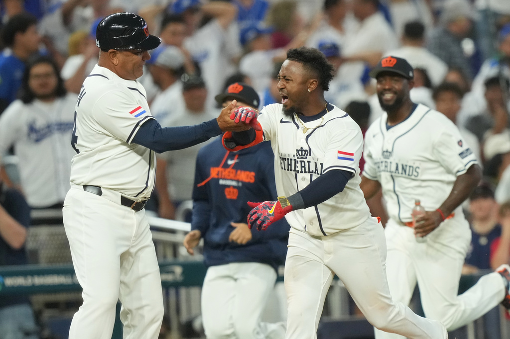 Netherlands' Ozzie Albies celebrates his three-run home run with third base coach Ben Thijssen during the ninth inning of a World Baseball Classic game against Nicaragua, Saturday, March 7, 2026, in Miami. (AP Photo/Marta Lavandier)