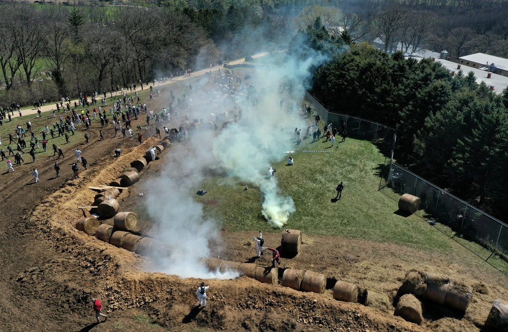 Animal rights activists react to tear gas while attempting to gain entry into Ridglan Farms beagle breeding and research facility in Blue Mounds, Wis., Saturday, April 18, 2026. (Amber Arnold/Wisconsin State Journal via AP)