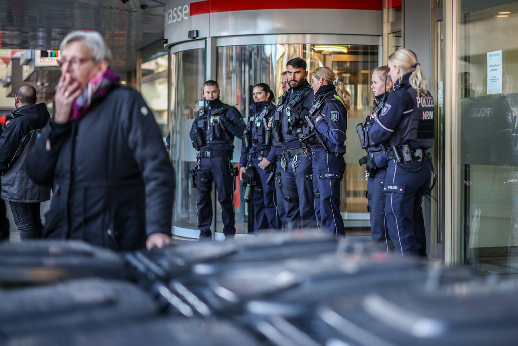 Police officers stand in front of the savings bank branch in the Buer district in Gelsenkirchen, Germany, Tuesday, Dec. 30, 2025 following a break-in into the bank's vault. (Christoph Reichwein/dpa via AP)
