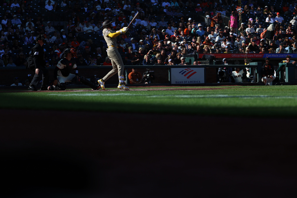 San Diego Padres' Jackson Merrill, front right, watches his two-run double in front of San Francisco Giants catcher Andrew Knizner, second from front left, during the first inning of a baseball game in San Francisco, Sunday, Sept. 13, 2026. (AP Photo/Jed Jacobsohn)