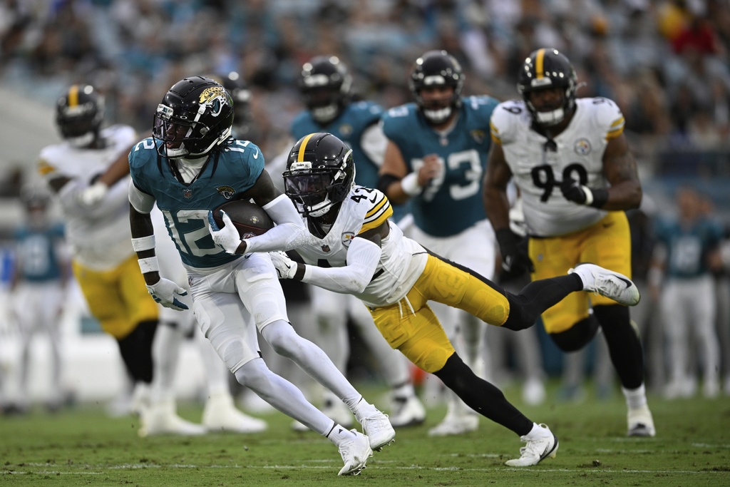 Jacksonville Jaguars wide receiver Travis Hunter (12) is tackled by Pittsburgh Steelers' James Pierre (42) during the first half of an NFL preseason football game, Saturday, Aug. 9, 2025, in Jacksonville, Fla. (AP Photo/Phelan M. Ebenhack)