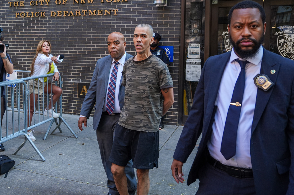 Raul Morales, center, a 51-year-old man who is accused of stabbing two people on the Upper West Side in Manhattan on Thursday afternoon is escorted out of the NYPD 20th Precinct by police officers in New York, Friday, July 24, 2026. (AP Photo/Ryan Murphy)