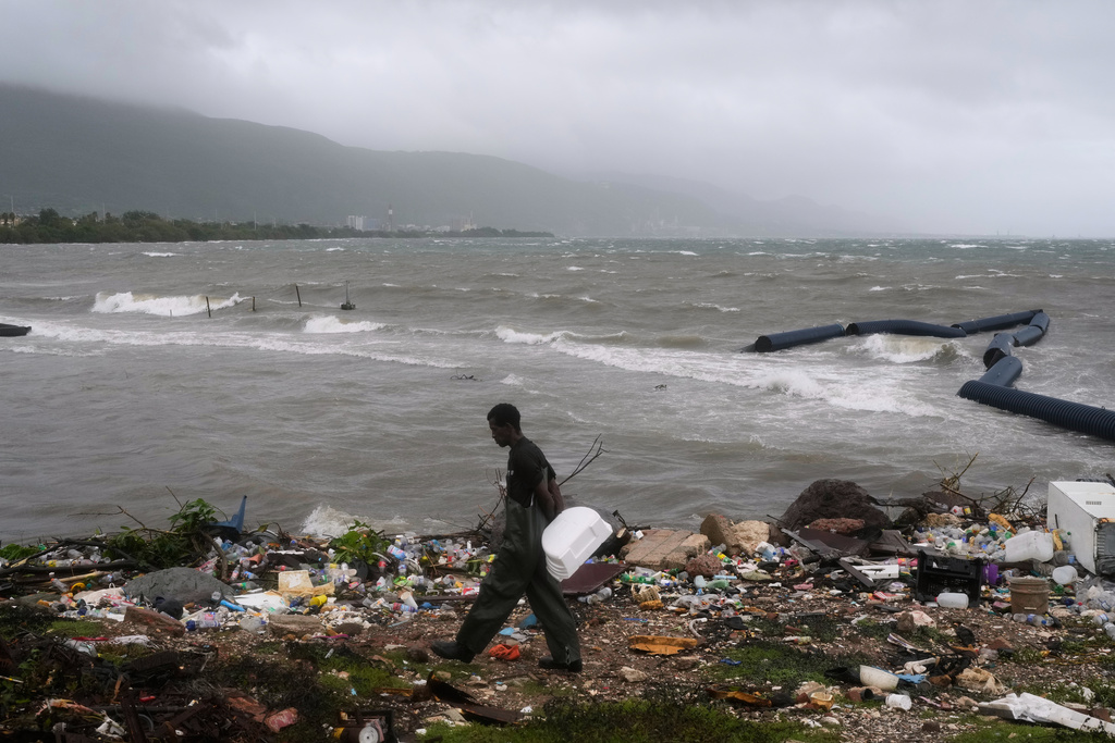 A man walks along the coastline during the passing of Hurricane Melissa in Kingston, Jamaica, Tuesday, Oct. 28, 2025. (AP Photo/Matias Delacroix)
